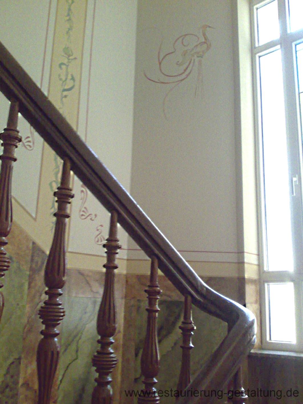 Nachdem die normalen Malerarbeiten im Treppenhaus fertig waren hat Malermeister Schimpf die historische Ausmalung in einer freien Gestaltung übernommen. Die Wandmalerei ist gegliedert in Oberwandflächen, die mit Schablonen und Bändern bemalt wurde. An den Podestflächen befindet sich ein Kranich / Vogel als Schmuckornament. Dieses Ornament stammt aus dem Jugendstil. Das Paneel wurde mit einer Marmorierung bemalt. Die Marmorimitation ist in Kassetten gegliedert. Diese Marmormalerei schützt strak vor Beschädigungen. An den Traljen ist eine Holzmalerei als Holzimitation zu sehen. Norbert Schimpf ist gelernter Malermeister und Techniker. Er Arbeitet als Restaurator für Malerei im Treppenhaus.